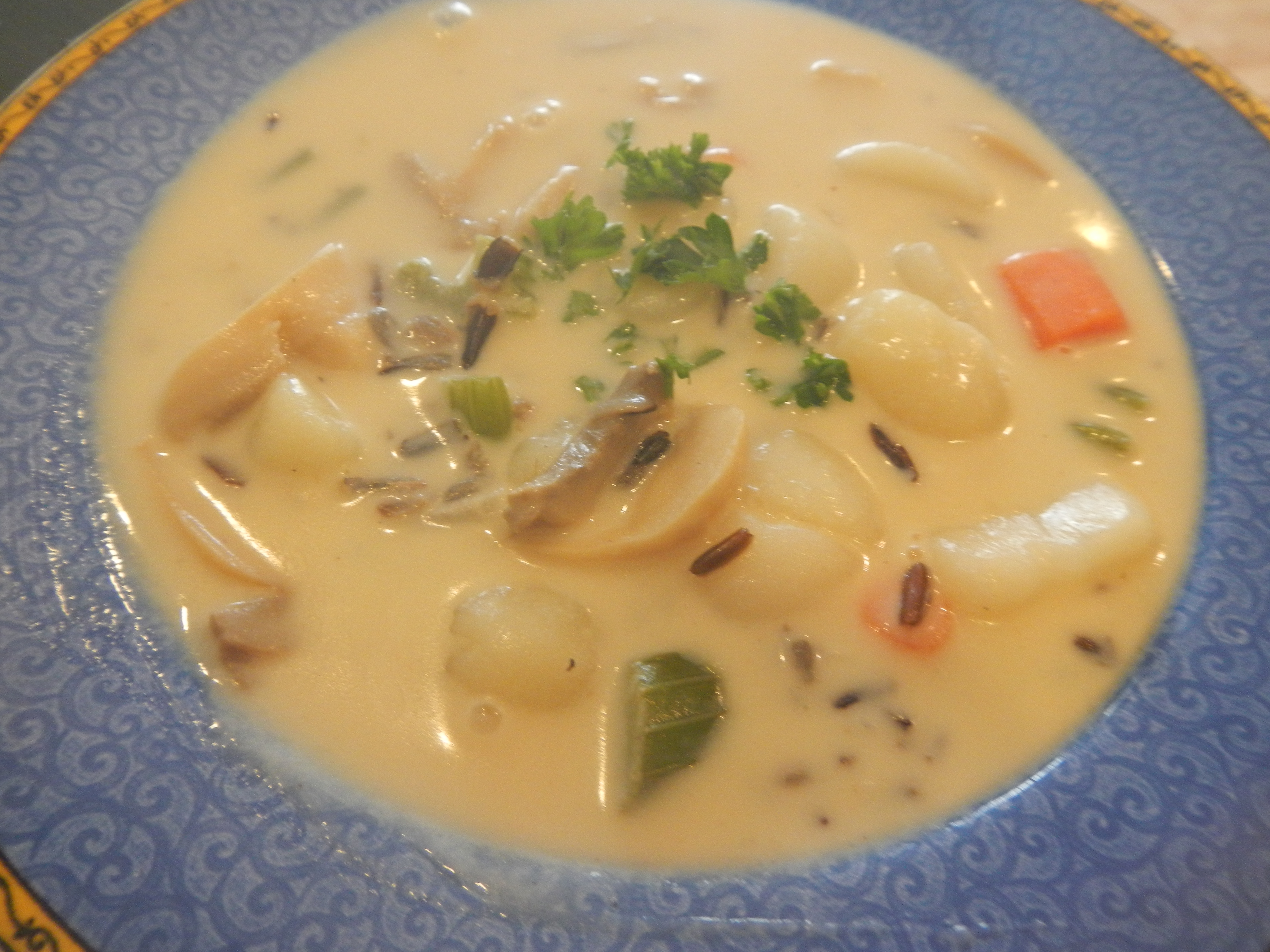 Image shows bowl of creamy wild rice soup.